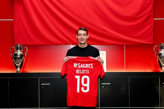 Andrea Belotti, avançado italiano ex-Como, segura a camisola do Benfica com o número 19