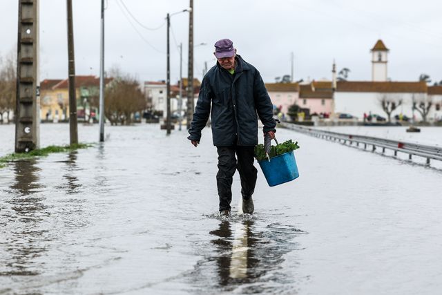 Um popular atravessa uma estrada de acesso a Ereira, inundada devido à passagem da depressão Leonardo, Montemor-o-Velho. Foto: MIGUEL A. LOPES/LUSA