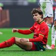 João Félix sentado no relvado durante um jogo do Milan, frente à Lazio