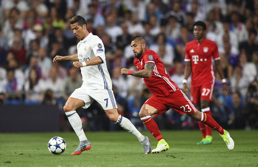 Cristiano Ronaldo escapa a Arturo Vidal no jogo da 2.ª mãos dos quartos de final entre Real Madrid e Bayern Munique, em 2018