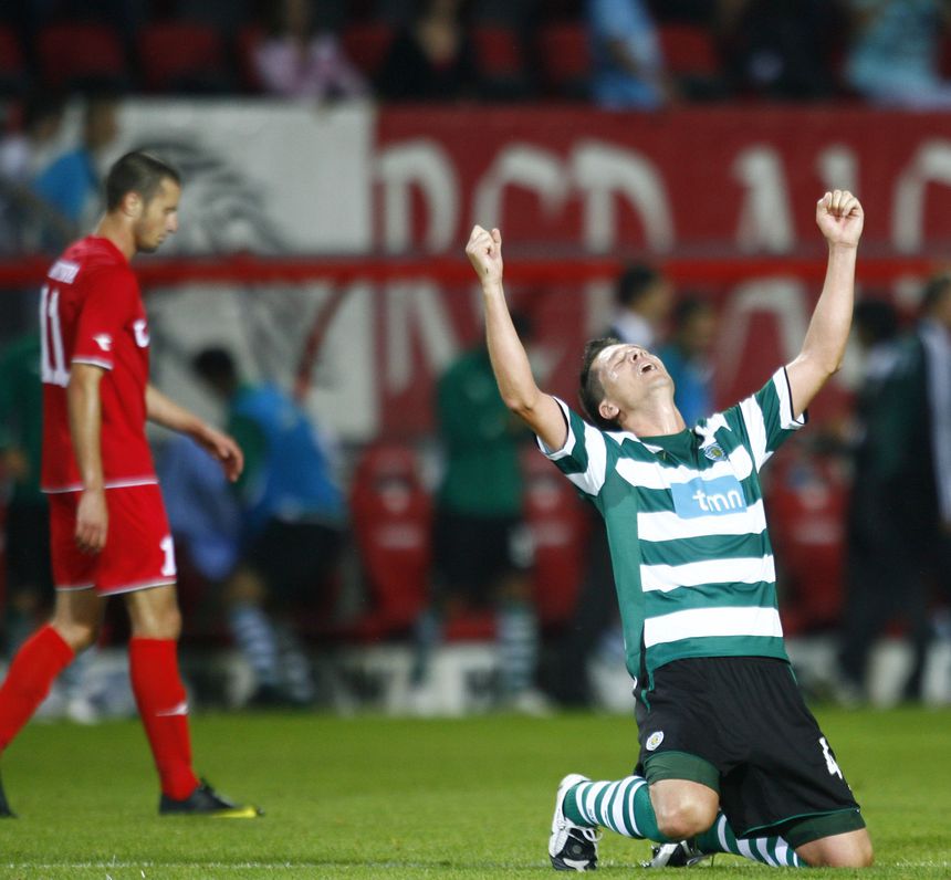 Anderson Polga, antigo central brasileiro do Sporting, celebra, de joelhos e braços erguidos aos céus, o apuramento do Sporting para o 'play-off' da Champions de 2009/10