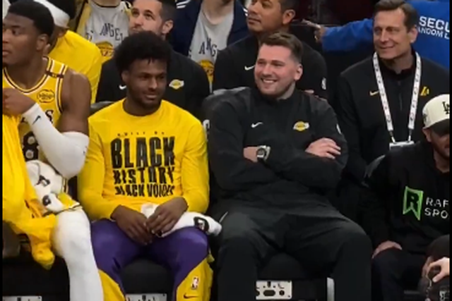 Luka Doncic sorri no banco dos Lakers, ao lado de Bronny James