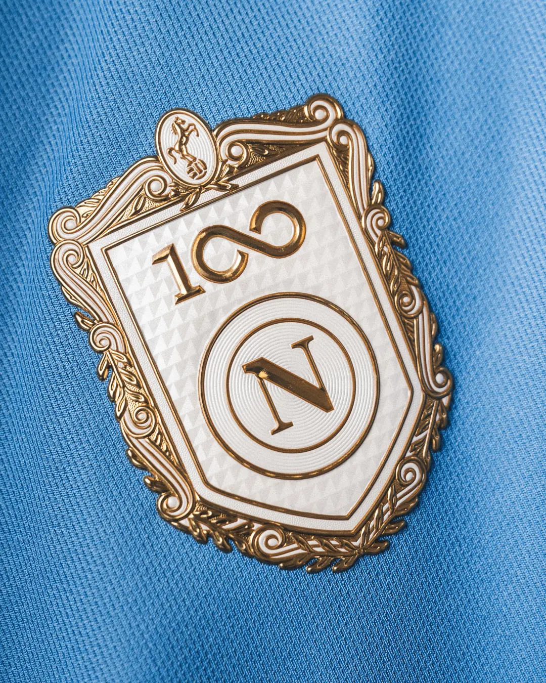Símbolo da camisola do Nápoles para 2026/27, que assinala o centenário do clube - Foto: Nápoles