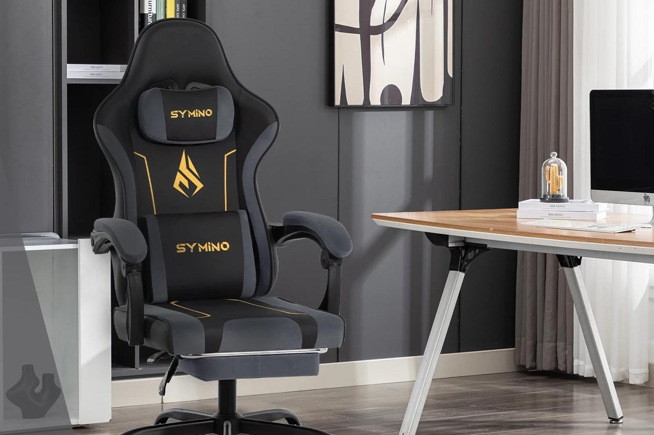 Cadeira gamer ergonómica Symino, com apoio lombar e cervical, posicionada num escritório moderno.