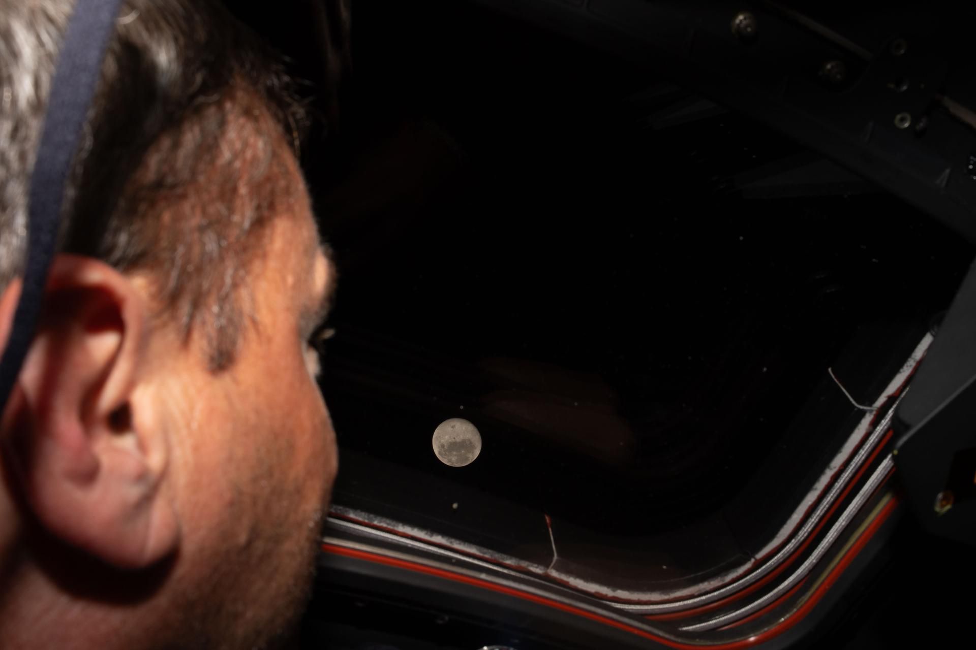 O comandante da Artemis II, Reid Wiseman, observa através de uma das janelas principais da cabine da nave Orion a Lua, antes do sobrevoo lunar da tripulação a 6 de abril de 2026 - foto: NASA