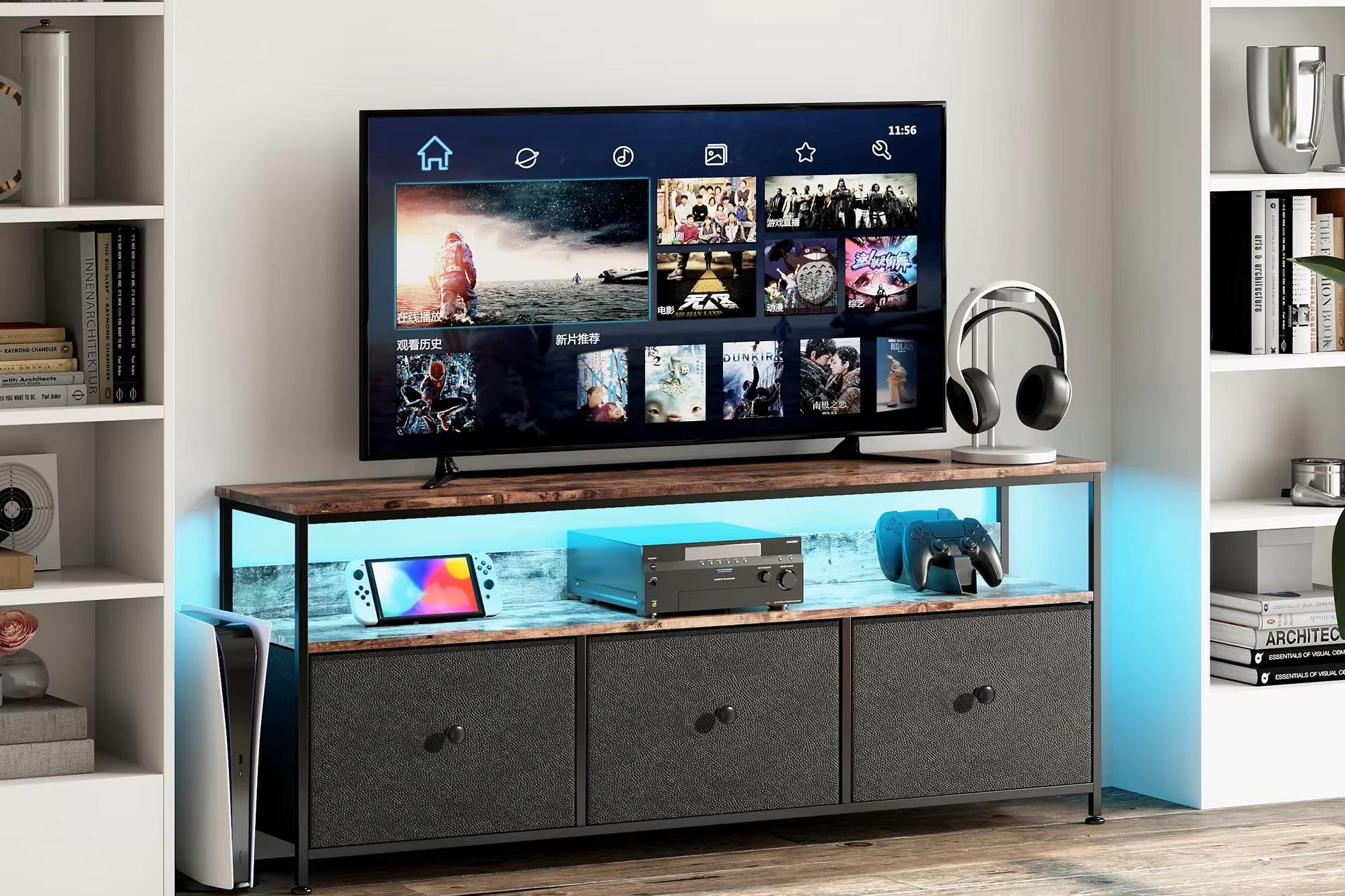 Armário de TV moderno, com iluminação LED azul ativada, três gavetas e um ecrã de televisão posicionado numa sala de estar.