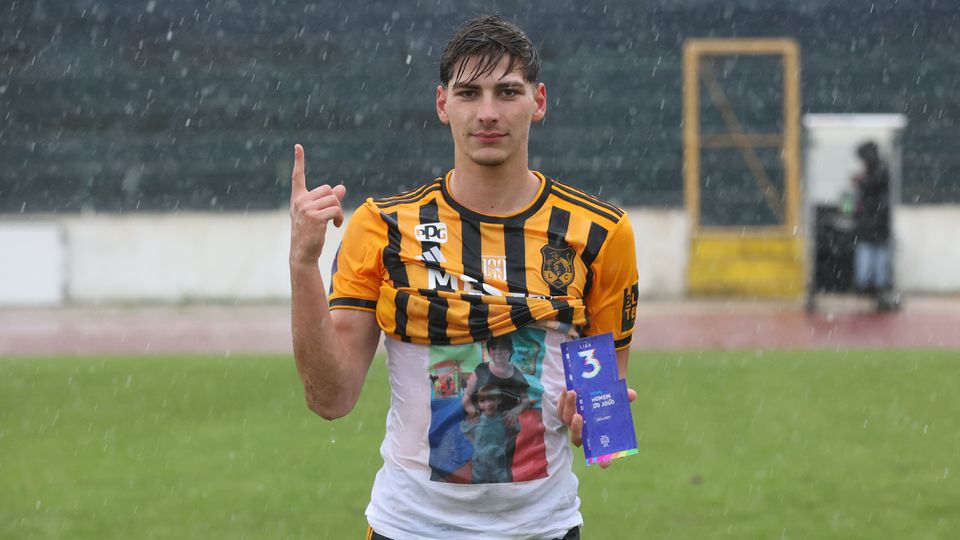 Bruno Faria, do Lusitânia de Lourosa, segura prémio de homem do jogo contra o 1.º Dezembro, a quem marcou dois golos, e aponta para o céu para dedicar exibição à falecida mãe