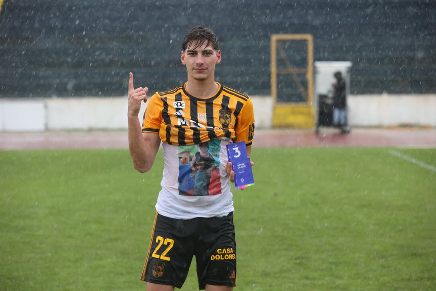 Bruno Faria, do Lusitânia de Lourosa, segura prémio de homem do jogo contra o 1.º Dezembro, a quem marcou dois golos, e aponta para o céu para dedicar exibição à falecida mãe