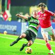 Carreras, defesa-esquerdo do Benfica, tenta ultrapassar Hjulmand, médio do Sporting, que tenta um tackle para desarmar o espanhol das águias