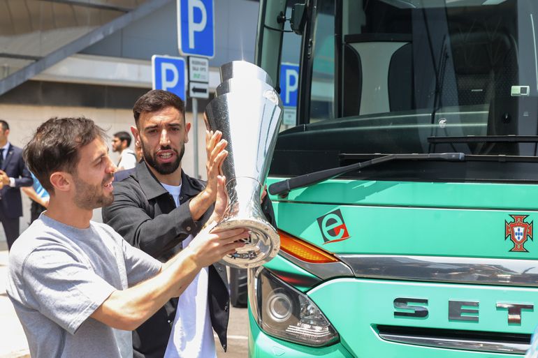 Bernardo Silva e Bruno Fernandes no aeroporto, com o troféu da Liga das Nações (Lusa)