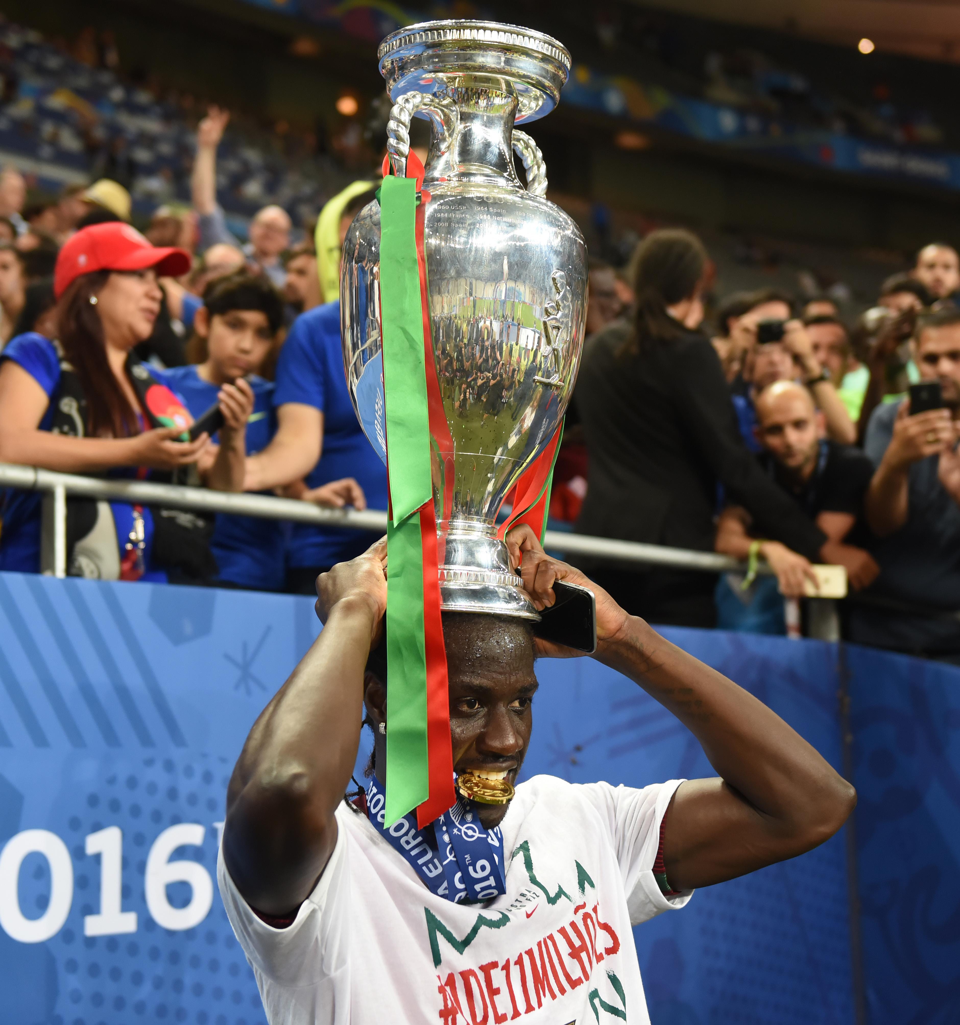 Éder, o autor do golo da final do Euro 2016, com o troféu em cima da cabeça e a medalha na boca (foto: Miguel Nunes)