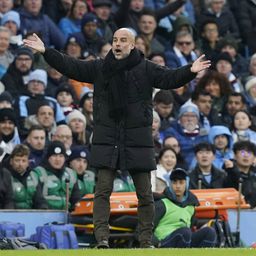 Pep Guardiola, treinador do Manchester City, de braços abertos virado para o relvado