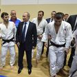 Vladimir Putin, presidente da Rússia, rodeado de judocas num ginásio