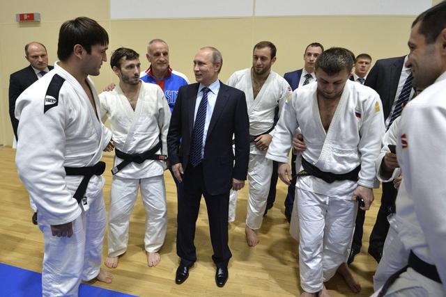 Vladimir Putin, presidente da Rússia, rodeado de judocas num ginásio