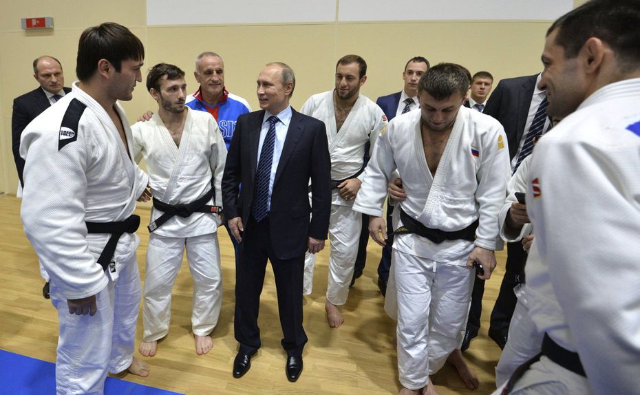 Vladimir Putin, presidente da Rússia, rodeado de judocas num ginásio