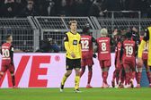 Yannik Luhrs vê jogadores do Bayer Leverkusen celebrarem um golo