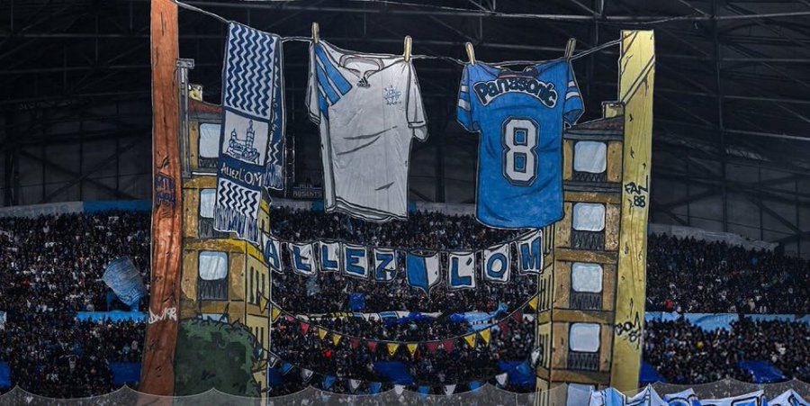 Marselha-Newcastle United (Liga dos Campeões, 25 de novembro de 2025)
Retrata roupas e cachecóis do clube estendidos numa corda, evocando o quotidiano dos bairros de Marselha e a forte ligação entre a cidade, os adeptos e o clube.
FOTO: X