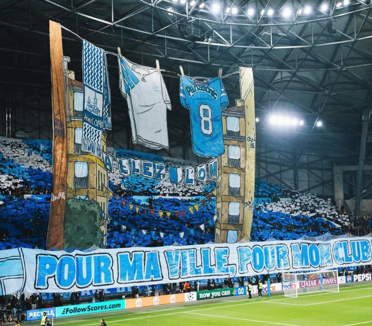 Marselha-Newcastle United (Liga dos Campeões, 25 de novembro de 2025)
Retrata roupas e cachecóis do clube estendidos numa corda, evocando o quotidiano dos bairros de Marselha e a forte ligação entre a cidade, os adeptos e o clube. 
FOTO: FACEBOOK