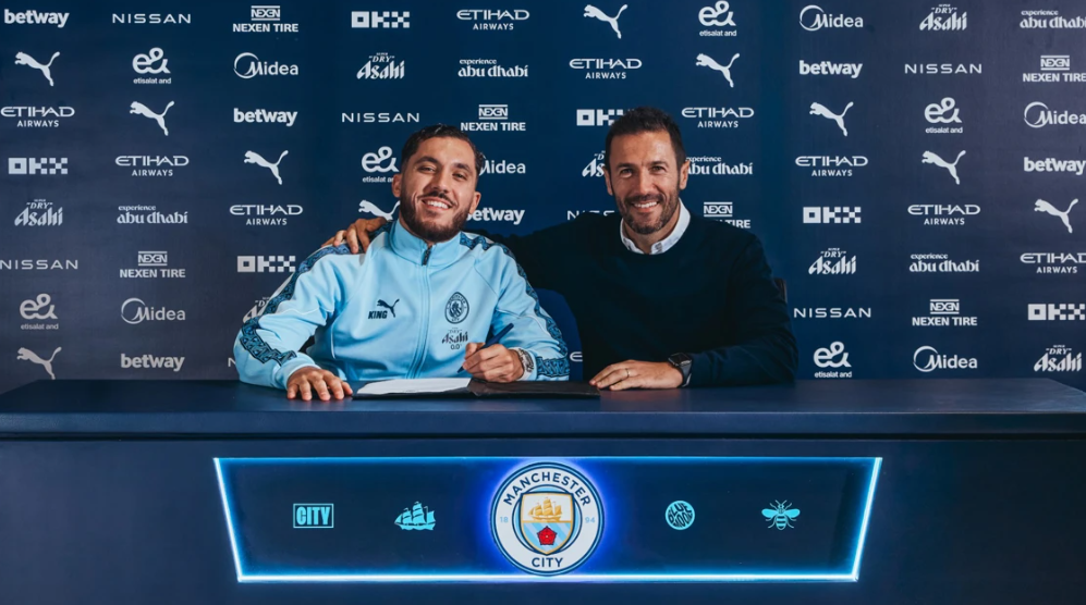 Rayan Cherki a assinar o contrato ao lado de Hugo Viana