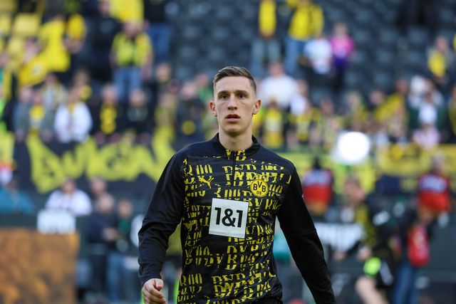 nico schlotterbeck, do borussia dortmund, realizando exercícios de aquecimento antes de um jogo da Bundesliga