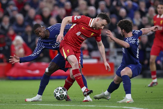 Diogo Jota a tentar manter a posse de bola, apesar da pressão de João Neves e Nuno Mendes