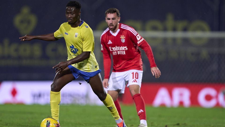 Sylla, médio do Arouca, tem a bola dominada perante a pressão de Kokçu, médio do Benfica