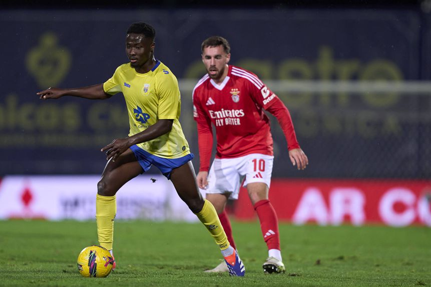 Sylla, médio do Arouca, tem a bola dominada perante a pressão de Kokçu, médio do Benfica