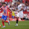 Julián Alvarez, avançado argentino do Atlético de Madrid, controla a bola perante a oposição, ainda que a alguma distância, de um jogador do Sevilha
