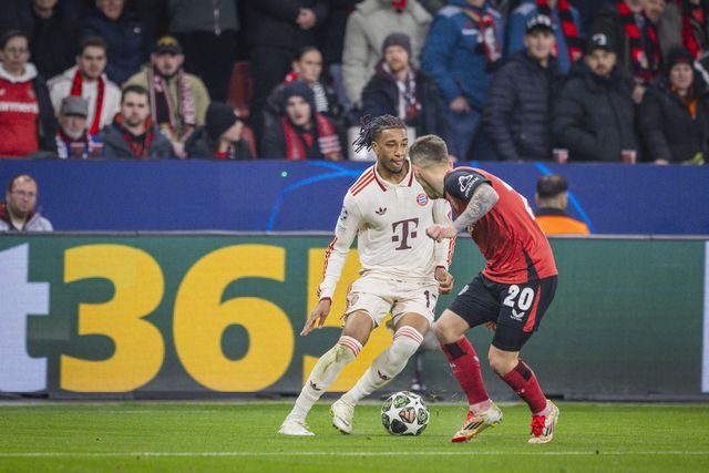 Michael Olise, extremo-direito do Bayern e Álex Grimaldo, lateral-esquerdo do Bayer Leverkusen