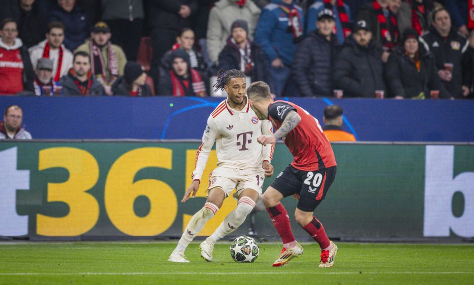 Michael Olise, extremo-direito do Bayern e Álex Grimaldo, lateral-esquerdo do Bayer Leverkusen