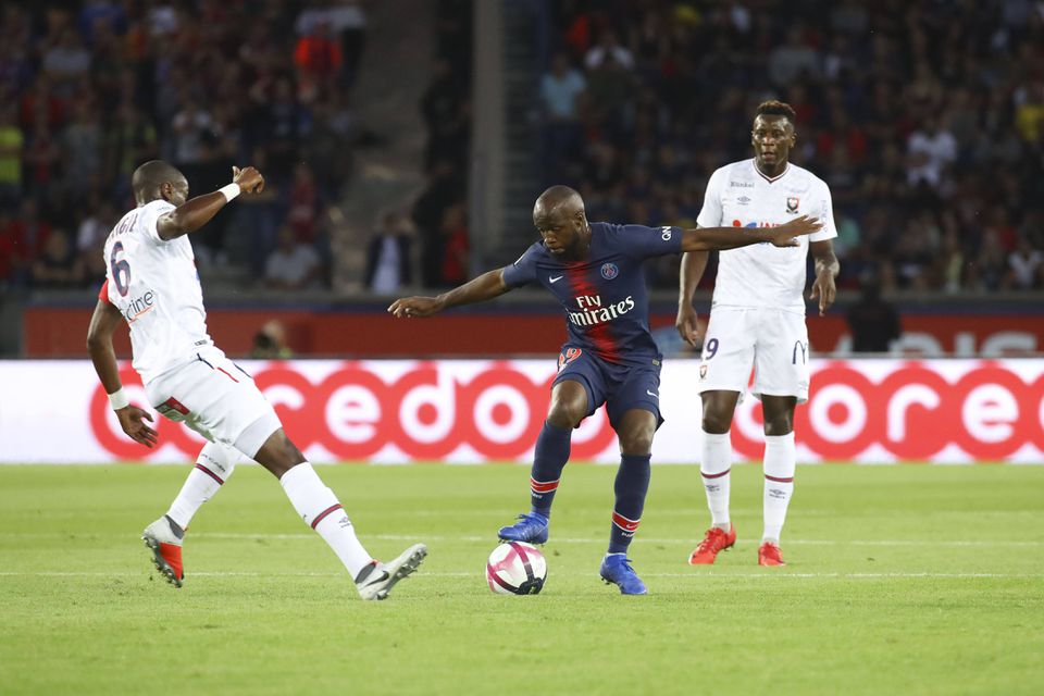 Imagem de Lassana Diarra com a camisola do PSG num jogo frente ao Caen em 2018. O médio dos parisienses tem a bola controlada e procura passar por dois adversários