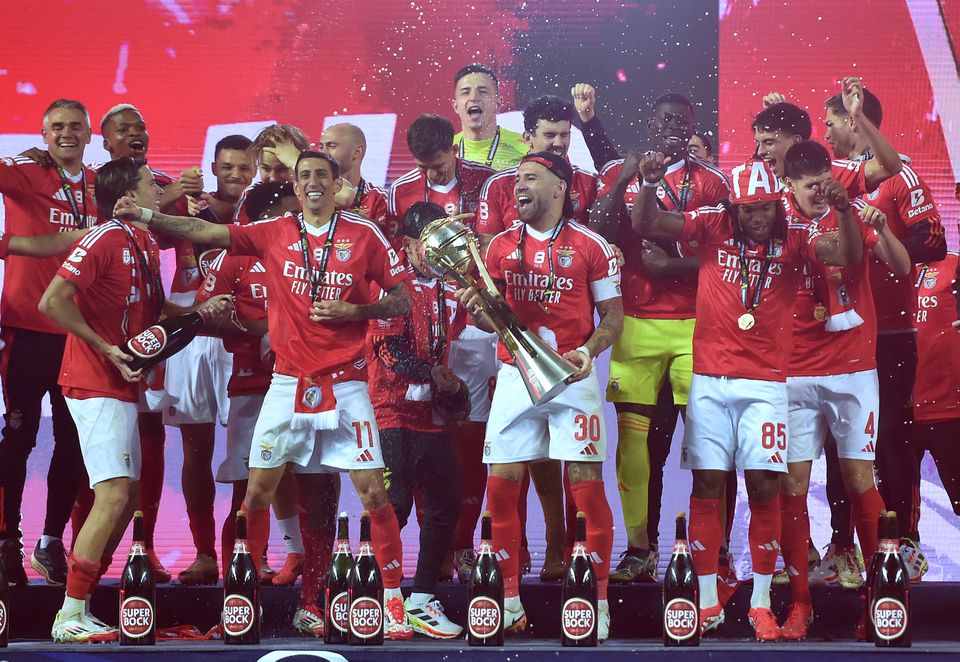 Otamendi, capitão do Benfica, com mais alguns companheiros a seu lado no palanque, segura no troféu da Taça da Liga que os encarnados conquistaram no último sábado ao derrotarem o Sporting na final por 7-6 nos penáltis após 1-1 nos 90 minutos