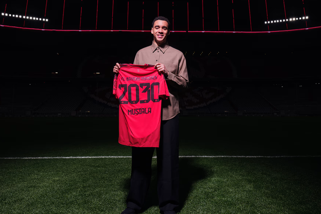 Foto do anúncio de renovação de Musiala com o Bayern, segurando a camisola com o número 2030, validade do contrato