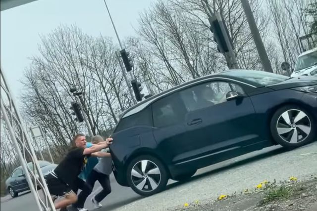 Dan Burn, jogador do Newcastle, a empurrar um carro avariado