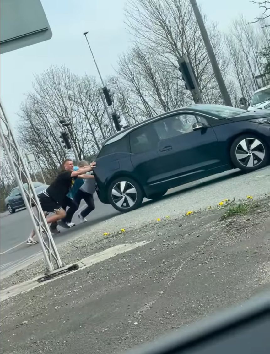 Dan Burn, jogador do Newcastle, a empurrar um carro avariado