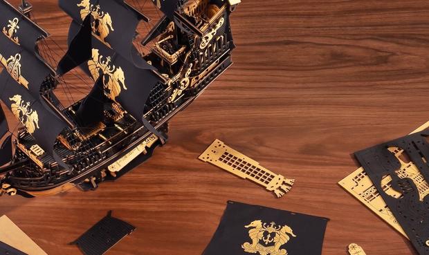 Puzzle 3D de um barco com peças em cima de uma mesa de madeira