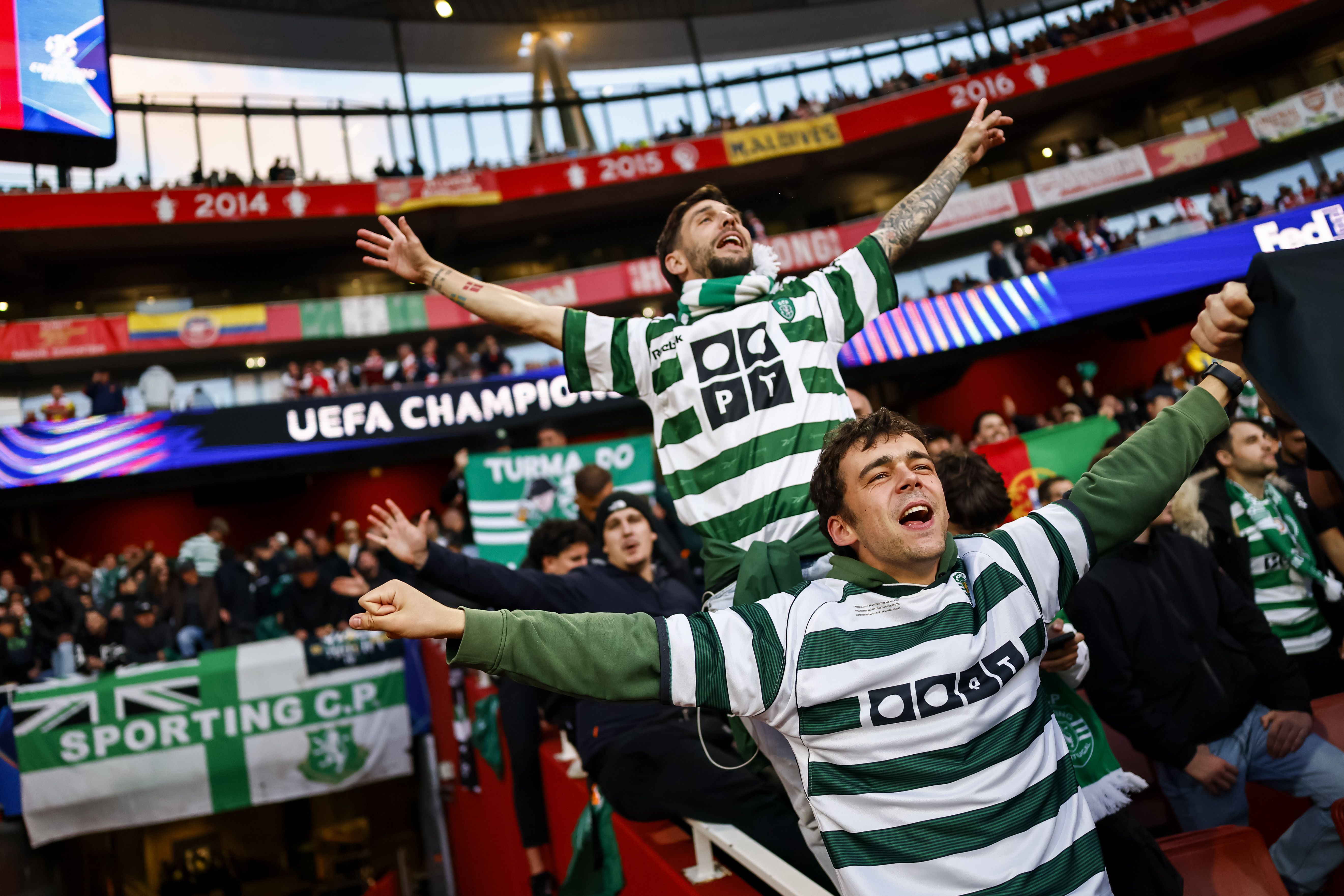 Afonso Figueiredo, antigo jogador, equipado de verde e branco entre os adeptos do Sporting no Emirates, onde os leões jogaram pelo apuramento para as meias-finais da Champions - Foto: EPA