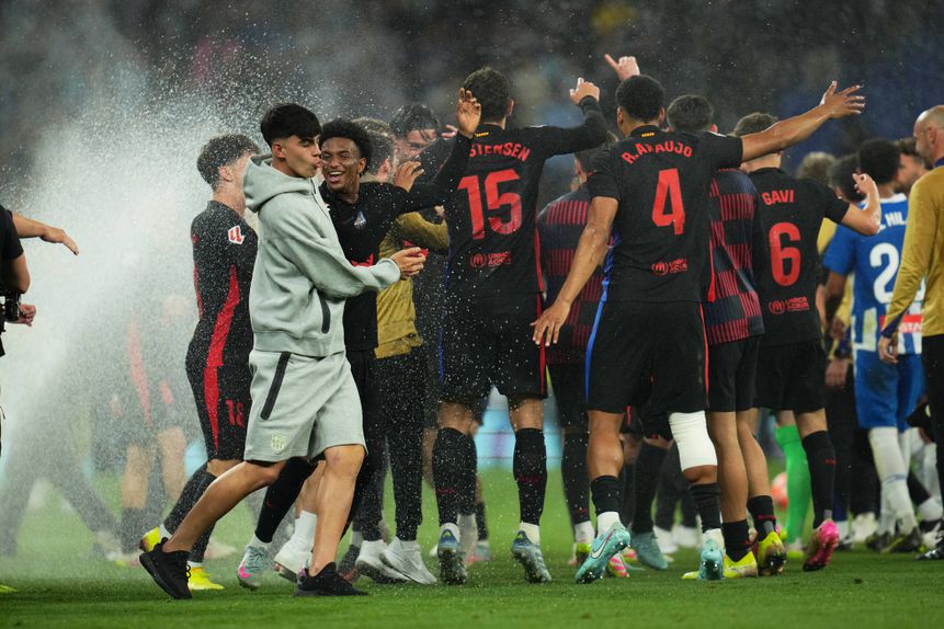 Festa dos jogadores do Barcelona, aos saltos, sob a rega do estádio do espanhol