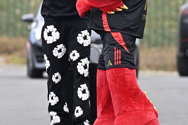 Zeno Debast na chegada à concentração da seleção belga, com umas calças pretas com flores brancas e recebido pelo diabo, mascote da equipa nacional