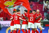 Jogadores do Benfica festejam, com uma bandeira dos encarnados como pano de fundo, um golo marcado no Estádio da Luz