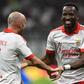 Lukebakio, sorridente e cumprimentado por Aursnes, depois de ter marcado o primeiro golo do Benfica na vitória sobre o Milan — Foto: IMAGO