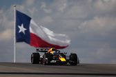 Max Verstappen no carro da Red Bull com a bandeira do Texas atrás