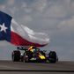 Max Verstappen no carro da Red Bull com a bandeira do Texas atrás