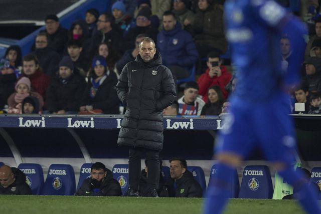Hansi Flick, treinador do Barcelona, a olhar para dentro das quatro linhas