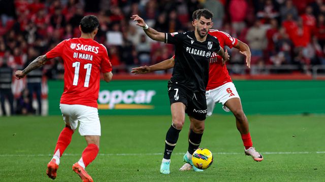 Nélson Oliveira, avançado do V. Guimarães, tem a bola controlada e procura fugir à marcação apertada de Bah (defesa do Benfica que atualmente recupera de lesão), sendo que Di María está na expectativa
