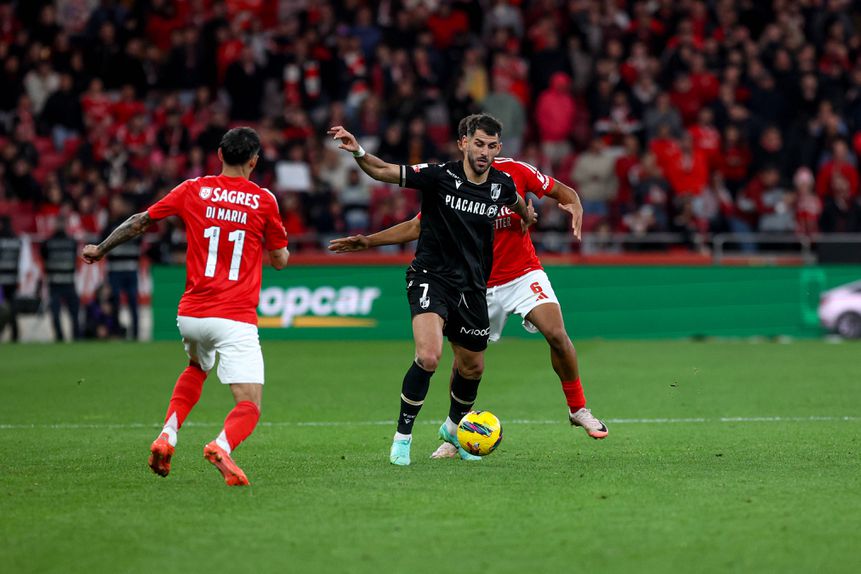 Nélson Oliveira, avançado do V. Guimarães, tem a bola controlada e procura fugir à marcação apertada de Bah (defesa do Benfica que atualmente recupera de lesão), sendo que Di María está na expectativa