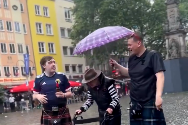 Adeptos da Escócia protegem idoso da chuva