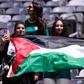 Adeptas seguram bandeira da Palestina no encontro entre França e Senegal no Mundial 2026