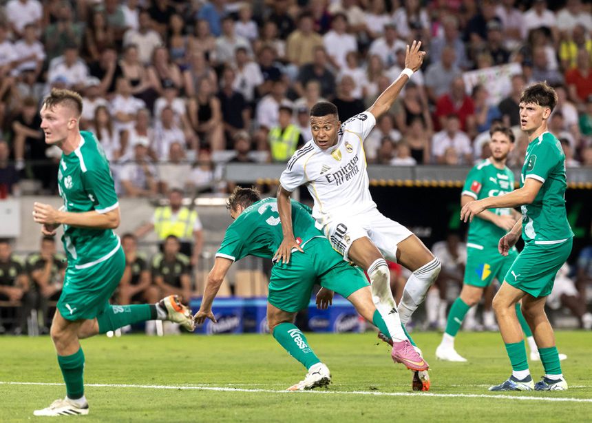 Kylian Mbappé cai de costas sobre o número 3 do Tirol, David Gugganig, durante o jogo particular com o Tirol. David Gugganing dobra-se sob o impacto do jogador francês