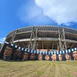 O novo mural à porta da casa do Estádio Diego Armando Maradona, com o recinto por trás